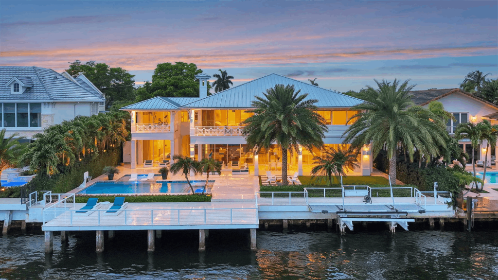 Luxury waterfront home in Coral Ridge, Fort Lauderdale, with private dock, pool, and palm-lined backyard.