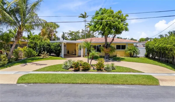 Elegant front exterior with professional landscaping, a grand entrance, and spacious driveway exuding curb appeal and sophistication.