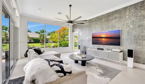 The spacious living room features large-format porcelain tile, custom feature walls, and panoramic water views.
