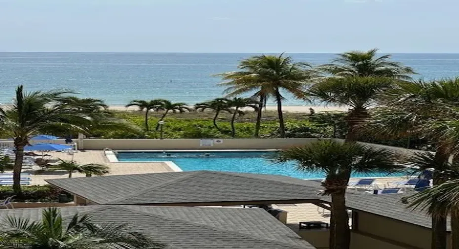 View from balcony over pool to beach and ocean