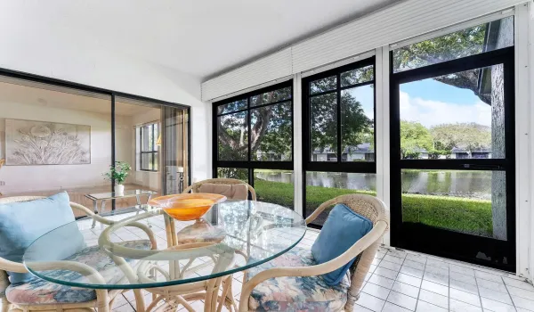Glass enclosed with roll down shutters and full accordion shutters access from living room, dining, and primary bedroom