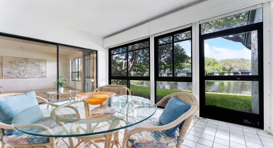 Glass enclosed with roll down shutters and full accordion shutters access from living room, dining, and primary bedroom