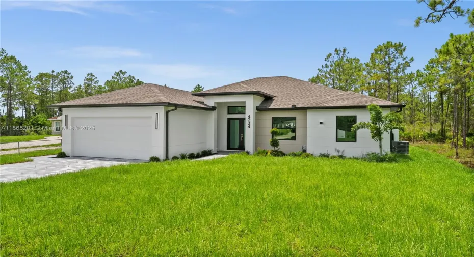 Prairie-style home with an attached garage,
roof with shingles, driveway, a front yard, and
stucco siding