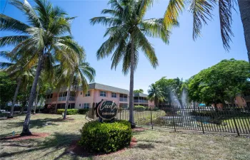 Front of the community overlooking a serene lake view with lush tropical surroundings.
