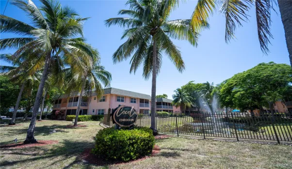 Front of the community overlooking a serene lake view with lush tropical surroundings.