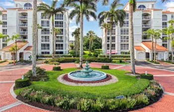 Well-maintained grounds with a central fountain, tropical landscaping, and secure building entrances offer a welcoming first impression.