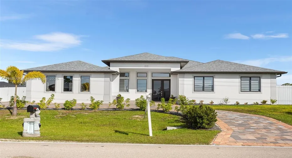 Luxurious style house with a shingled roof, a front yard, and stucco siding