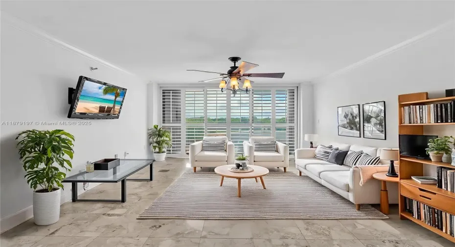 Living room with floor-to-ceiling windows opening to the balcony, offering ocean views and complete privacy with no nearby neighbors. Virtually staged furniture