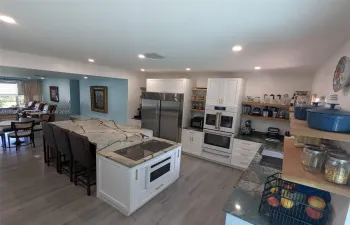 Luxurious kitchen with high ceiling, accented by designer recessed lighting and appliances matching the cabinetry that complement the space beautifully