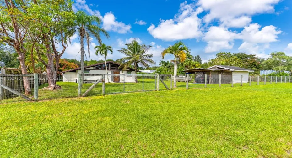 STREET VIEW OF THE COUNTRY HOME W/ CUTE FARM FENCING, DETACHED GARAGE WORKSHOP.