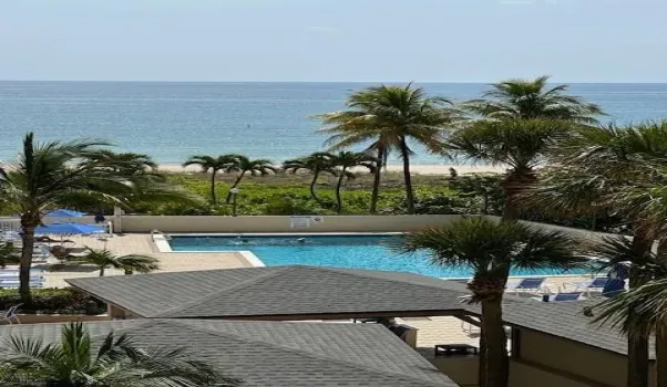 View from balcony over pool to beach and ocean