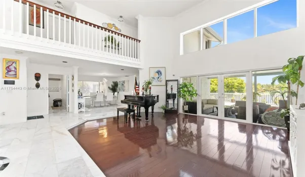 Grand living room with panoramic view to dining room, patio & pool deck