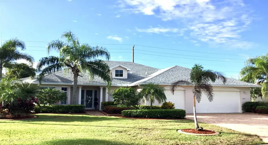 View of front of house featuring a 3 car attached garage, paver driveway, stucco CBS home with a 2025 new roof.