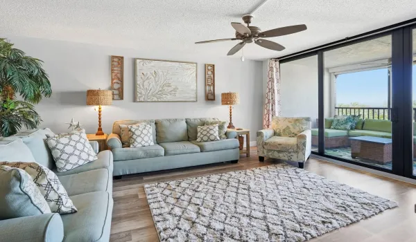 Living Room with 2 couches, chair, end tables, rug, TV stand, and a custom wood panel.