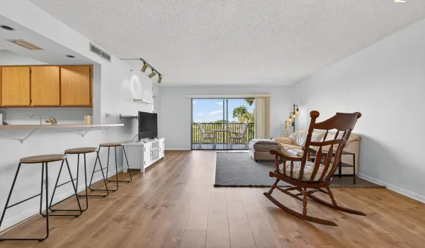 Light pours into this bright, beautiful living room, where you’re greeted with views of the pool, lake, and lush gardens. It’s the kind of space that just feels good the moment you walk in—airy, open, and full of natural charm.
