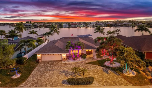 Welcome to the stunning evening setting at 626 Cape Coral Pkwy West. Twilight view of the lake