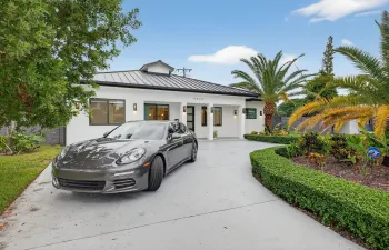 Oversized circular drive way with 50 foot tall palm trees and professionally landscaped front and backyard.