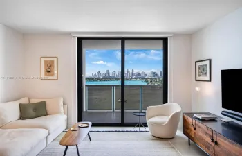 Bright, open living room with floor-to-ceiling glass and a private balcony