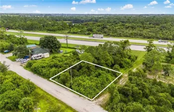 Aerial view of property and surrounding area with property boundaries highlighted and a heavily wooded area