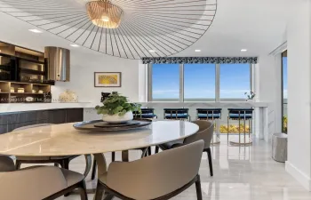 Open kitchen and dining with ocean backdrop.