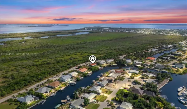 Aerial view capturing the full property and tranquil Gulf horizon during a breathtaking Florida sunset.