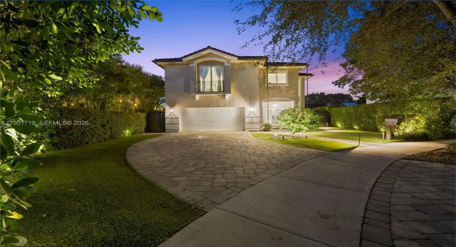 A bright and welcoming foyer features high-volume ceilings and polished marble-look flooring with a custom decorative medallion inlay.