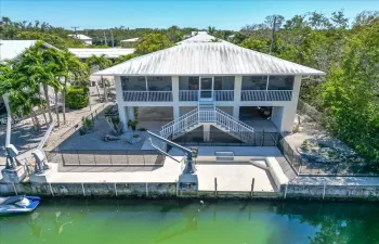 Florida Keys waterfront home in Big Pine Key featuring canal frontage and a full concrete seawall with direct boating access.