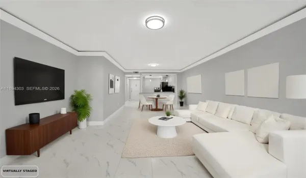 This bright, open living/dining space shows off the full renovation — glossy new marble-look tile floors throughout, fresh light gray paint on the walls, crisp new crown molding and baseboards, and updated modern lighting.