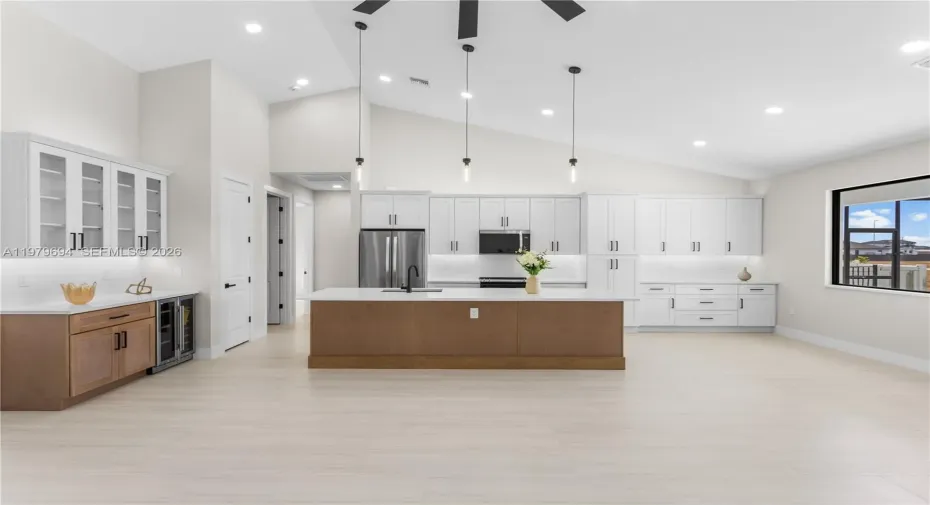 Crisp WHITE SHAKER CABINETRY is paired w/ contrasting warm WOOD-TONE ISLAND CABINETS & modern BLACK HARDWARE for a sophisticated coastal-modern design.