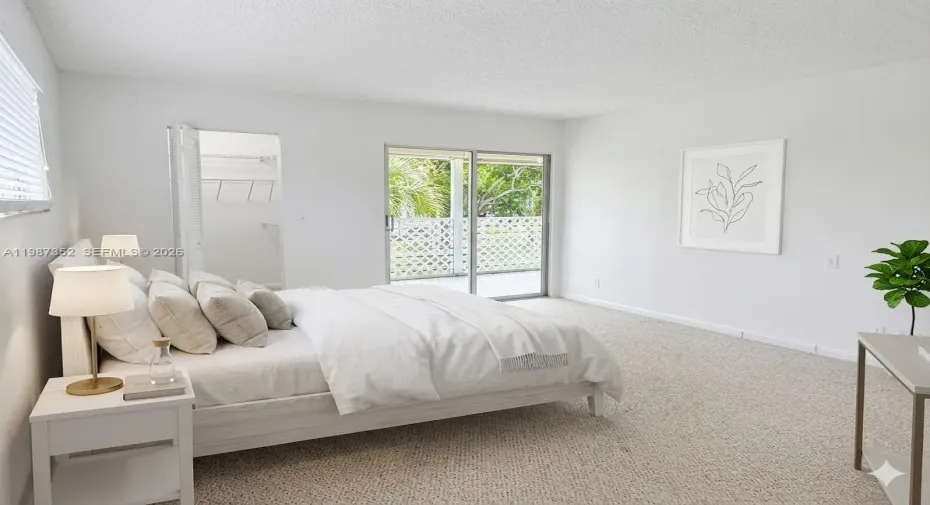 Large bedroom with balcony access, view, walk-in closet, and ensuite bathroom. Virtually staged.