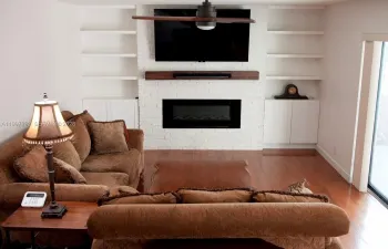 Custom wall with built-in cabinetry and shelves, including an electric fireplace