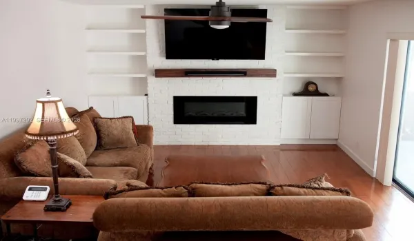 Custom wall with built-in cabinetry and shelves, including an electric fireplace