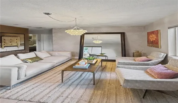 Bright, open-concept living room with tile floors &mdash; fully renovated ground-floor corner unit