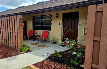 Inviting front entry porch featuring a private, fenced seating area.