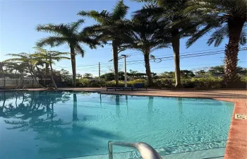 Sunny pool area with lounge chairs, perfect for relaxing and enjoying.