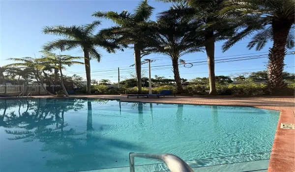 Sunny pool area with lounge chairs, perfect for relaxing and enjoying.