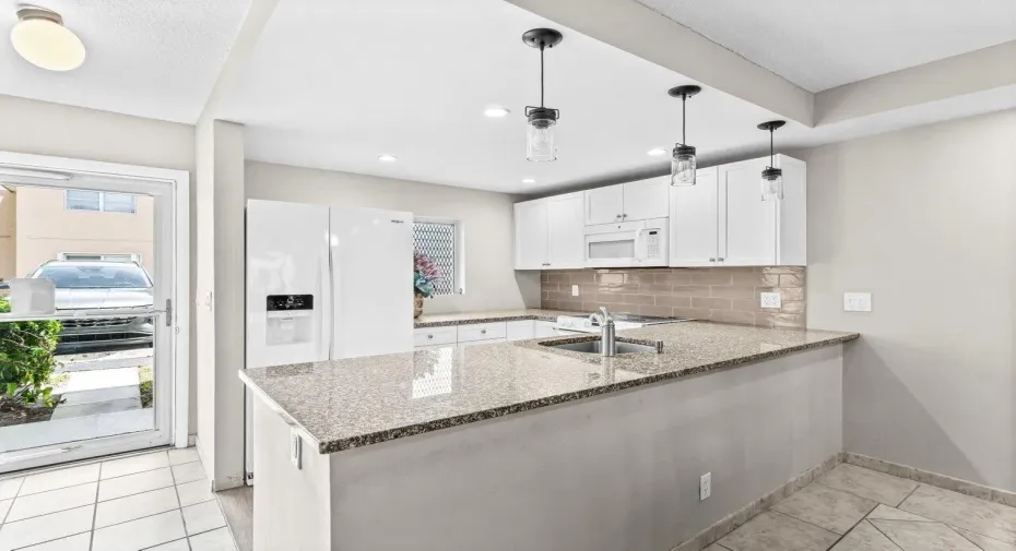 REMODELED, GROUND FLOOR END UNIT. Fabulous location near the beach, shopping, dining, airports and more! Modern kitchen with white shaker cabinetry, granite countertops and porcelain wood tile flooring. Open floorplan!