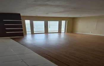 Living Room with tile and laminate floors.New double doors leading ro wrap around porch