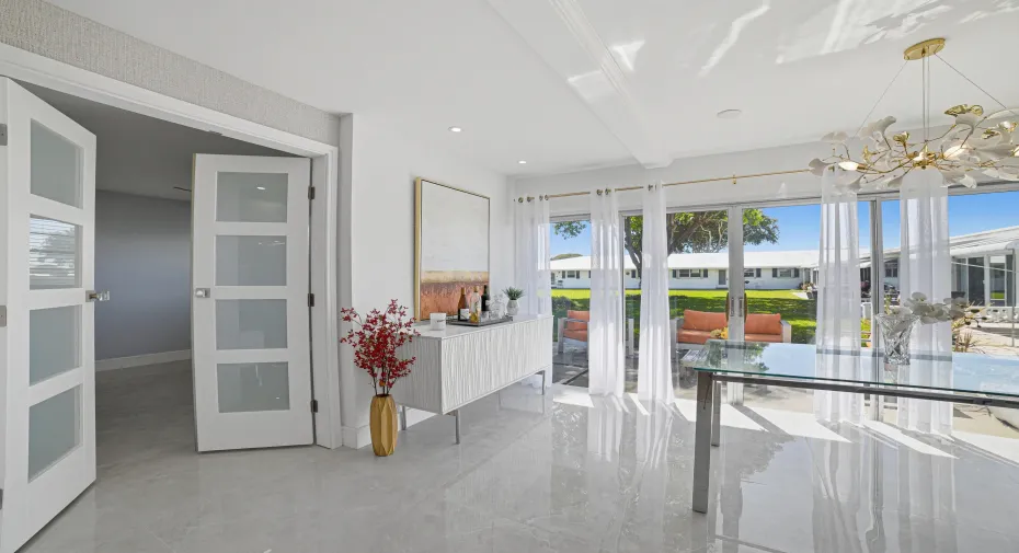Spacious and bright dining area with view of patio and garden. Large Hurricane Impact sliding doors provide safety
