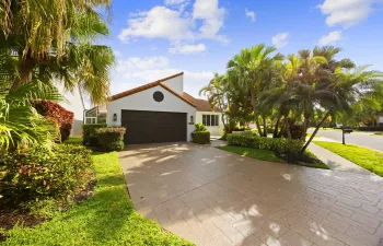 Beautifully landscaped curb appeal welcomes you home in the desirable Copper Lake subdivision of Newport Bay Club, featuring a wide, extended driveway, 2-car garage, and lush tropical greenery that creates a private, inviting entrance. The clean architectural lines, tile roof, and mature palms set the tone for a true South Florida lifestyle from the moment you arrive.