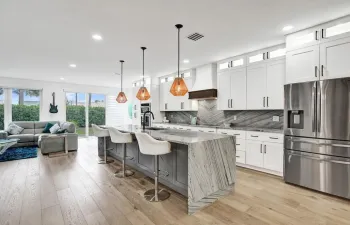 This meticulous newly renovated home boasts the bright open concept with floor to wall hurricane impact windows and high ceilings.