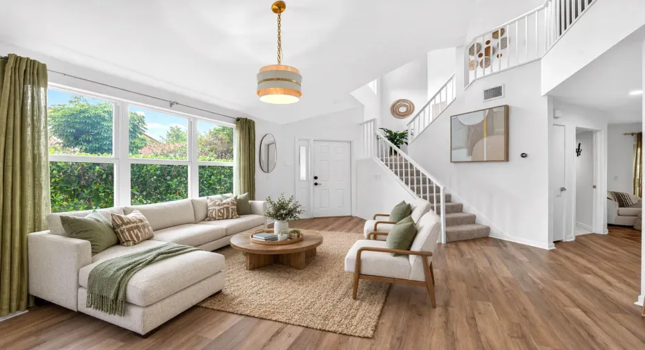 Spacious living room boasts new luxury vinyl plank flooring is ready for family gatherings. (virtually staged)