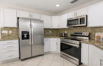 Bright and modern kitchen featuring stainless steel appliances and granite countertops.