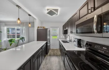 Large Galley Kitchen - Espresso cabinets and Quartz countertops