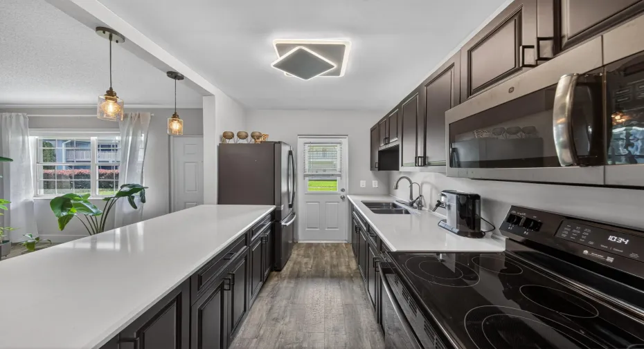 Large Galley Kitchen - Espresso cabinets and Quartz countertops