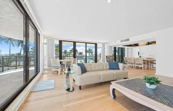 Large open living room surrounded by deep balcony and floor to ceiling windows