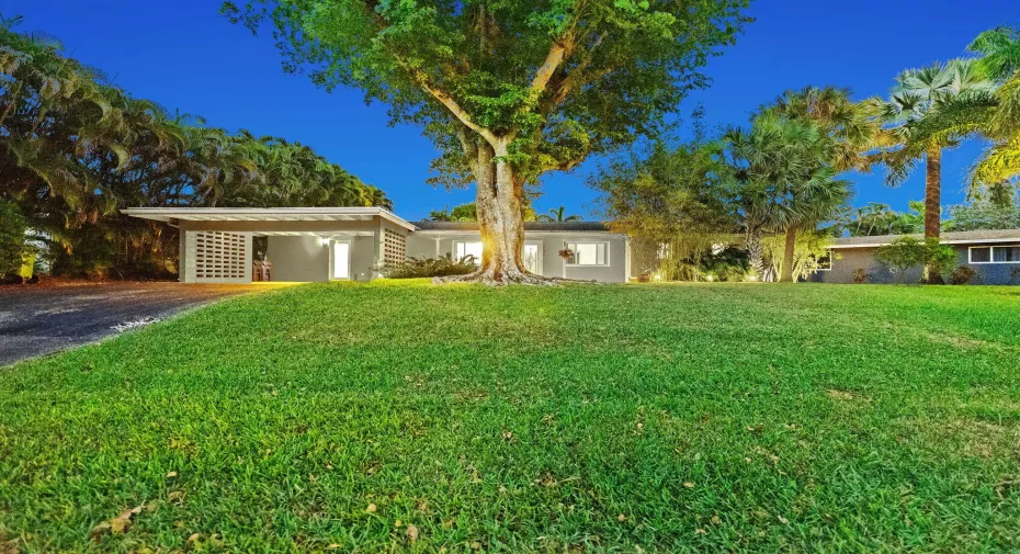 Front of home at twilight with landscape lighting.