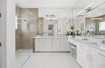 Renovated primary bathroom with new tile flooring, roll in shower, new lighting, fixtures and floor to ceiling wall shower tile. Double sinks. Linen closet. Private water closet.