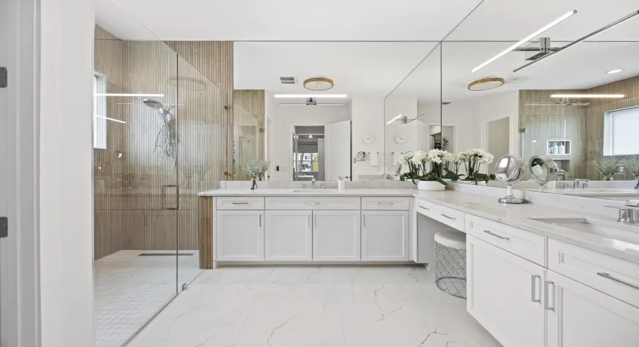 Renovated primary bathroom with new tile flooring, roll in shower, new lighting, fixtures and floor to ceiling wall shower tile. Double sinks. Linen closet. Private water closet.