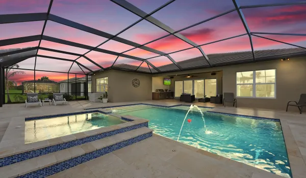 Heated pool and 6 person spa, with travertine tiles surrounding the screened area. Summer kitchen is a plus for outdoor entertaining